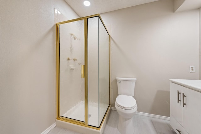 bathroom featuring vanity, toilet, and an enclosed shower