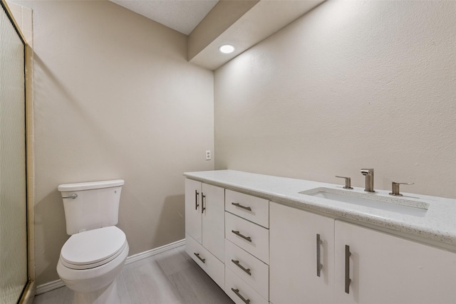 bathroom with vanity, toilet, and wood-type flooring