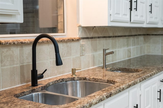 kitchen with decorative backsplash, white cabinetry, and sink