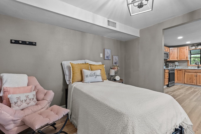 bedroom featuring sink and light hardwood / wood-style flooring