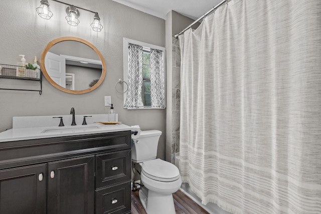 full bathroom with hardwood / wood-style flooring, shower / tub combo with curtain, vanity, and toilet