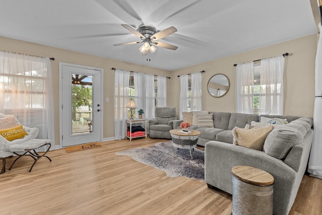 living room featuring ceiling fan and light hardwood / wood-style floors