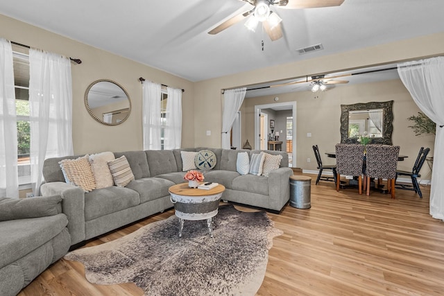 living room featuring ceiling fan and light hardwood / wood-style flooring