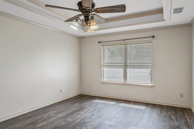 spare room featuring ornamental molding, a tray ceiling, ceiling fan, and dark wood-type flooring