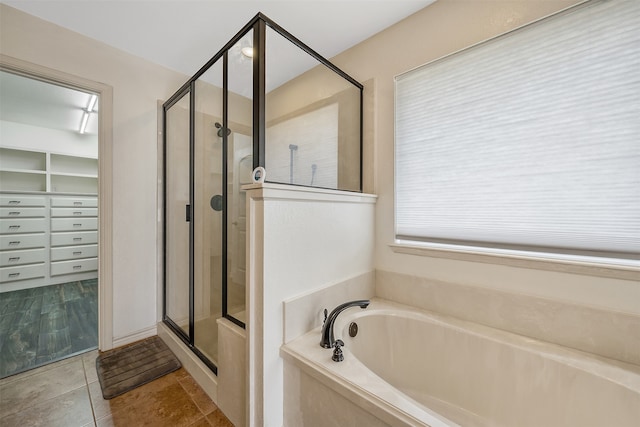 bathroom with shower with separate bathtub and tile patterned floors