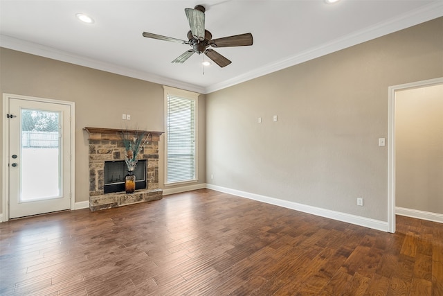 unfurnished living room featuring ceiling fan, a stone fireplace, crown molding, and dark hardwood / wood-style flooring