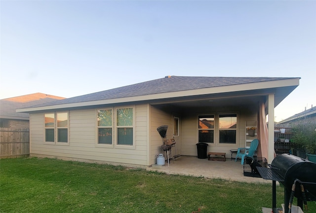 back of property with a patio area and a yard