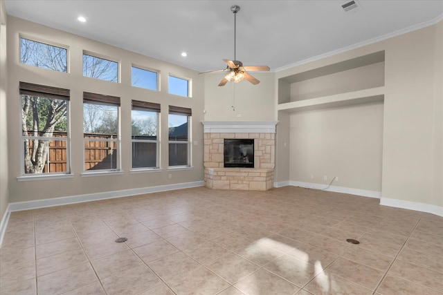 unfurnished living room with light tile patterned floors, a fireplace, visible vents, a ceiling fan, and baseboards