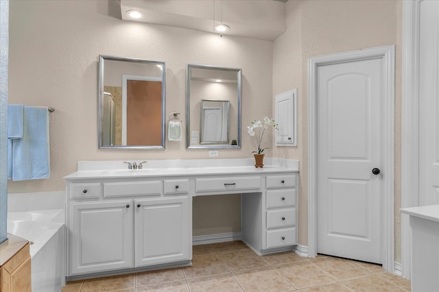 bathroom with a garden tub, tile patterned flooring, and vanity