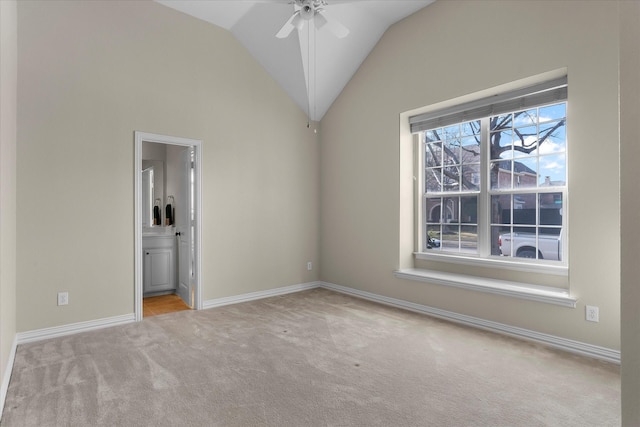 unfurnished bedroom with light carpet, baseboards, connected bathroom, and lofted ceiling