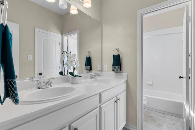 bathroom with double vanity, tile patterned flooring, toilet, and a sink