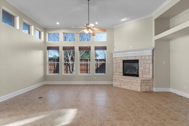 unfurnished living room with a wealth of natural light, crown molding, baseboards, and light tile patterned floors