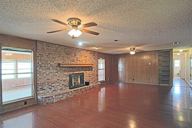 unfurnished living room featuring a textured ceiling, plenty of natural light, and dark hardwood / wood-style flooring