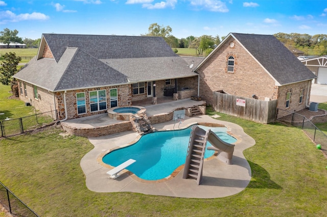 view of swimming pool with a diving board, a lawn, a patio, and an in ground hot tub