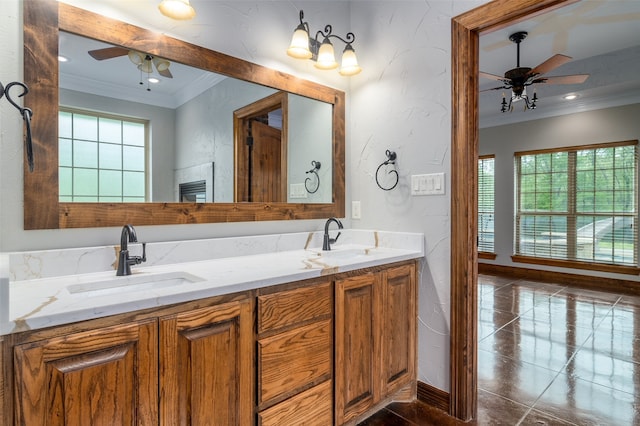 bathroom featuring ceiling fan, a healthy amount of sunlight, ornamental molding, and vanity