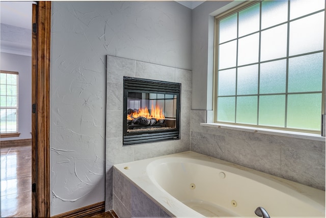 bathroom featuring a relaxing tiled tub and crown molding