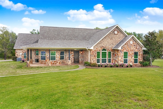 view of front of house featuring a front lawn and central air condition unit