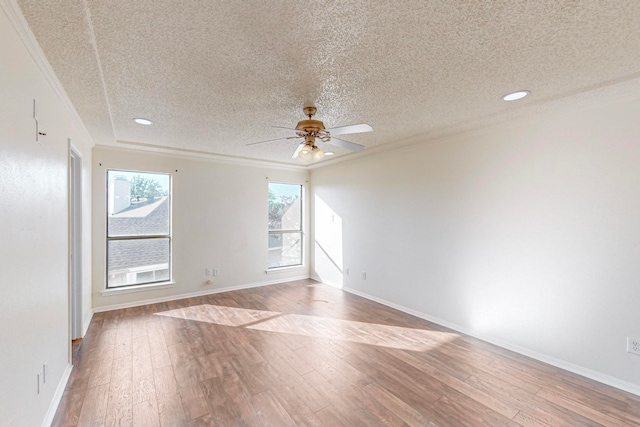 empty room with ceiling fan, hardwood / wood-style flooring, ornamental molding, and a textured ceiling