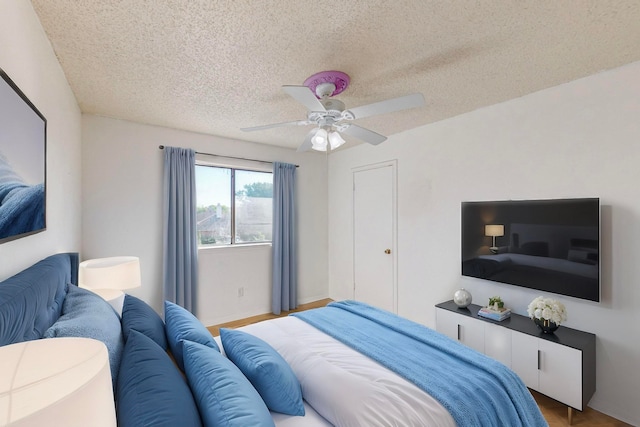 bedroom featuring ceiling fan, a textured ceiling, and wood-type flooring