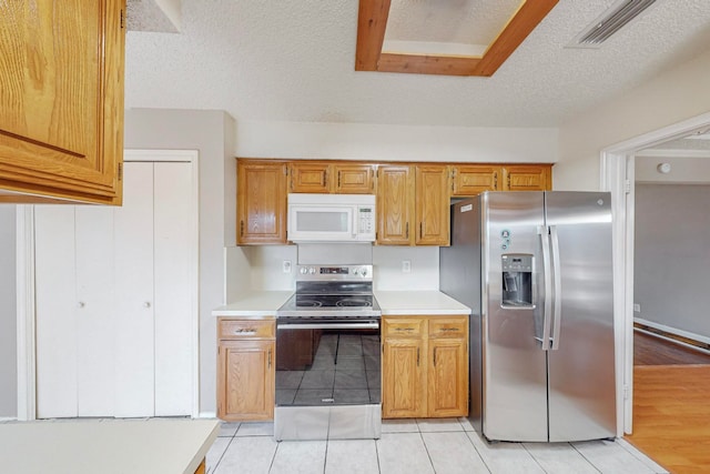 kitchen featuring a textured ceiling, appliances with stainless steel finishes, and light wood-type flooring