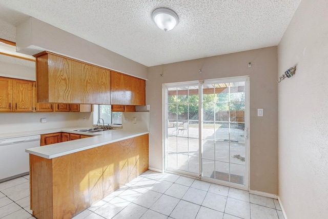 kitchen with light tile patterned floors, dishwasher, sink, and kitchen peninsula