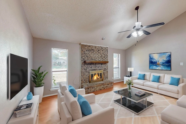 living room with a textured ceiling, light hardwood / wood-style floors, vaulted ceiling, and a fireplace