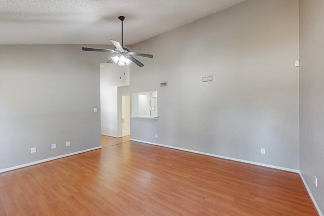 unfurnished room with ceiling fan, a textured ceiling, light wood-type flooring, and high vaulted ceiling