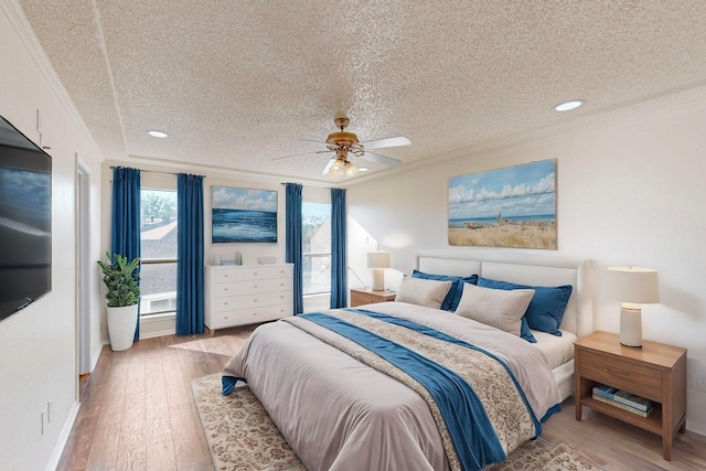 bedroom with ceiling fan, a textured ceiling, light hardwood / wood-style flooring, and ornamental molding