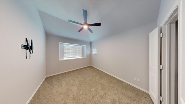 spare room with light carpet, vaulted ceiling, and ceiling fan