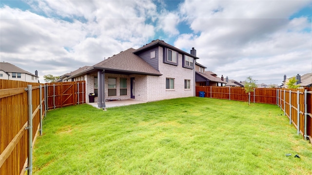 rear view of property with a yard and a patio area