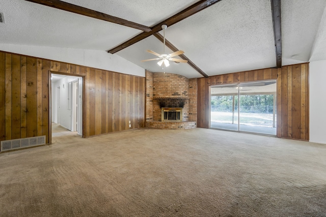 unfurnished living room featuring ceiling fan, a fireplace, light colored carpet, and wood walls