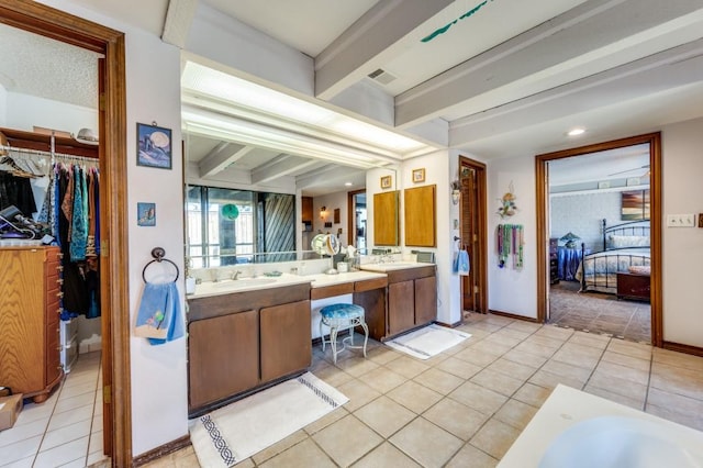 bathroom with tile patterned flooring, vanity, a bathtub, and beam ceiling