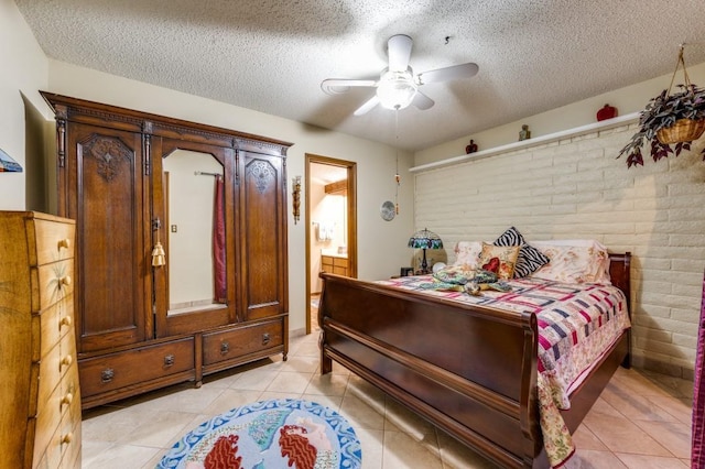 bedroom featuring ceiling fan, connected bathroom, a textured ceiling, and light tile patterned floors