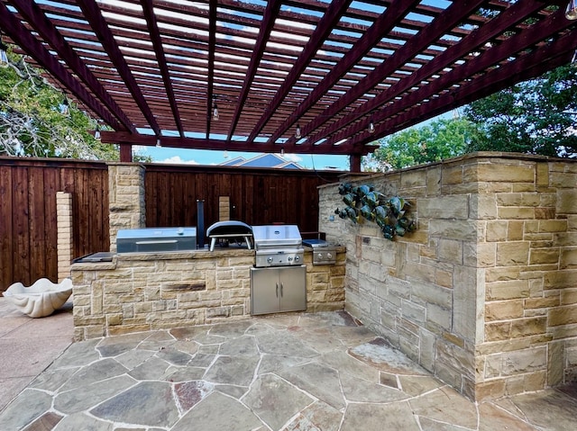 view of patio with area for grilling, a grill, and a pergola