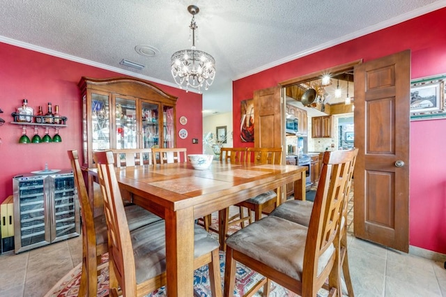 tiled dining space featuring wine cooler, crown molding, and a textured ceiling