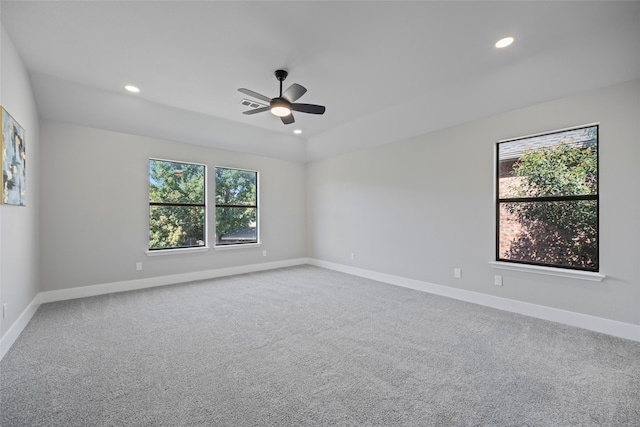 carpeted spare room featuring ceiling fan and a healthy amount of sunlight