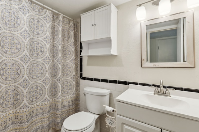 bathroom with tile walls, vanity, toilet, and a shower with curtain