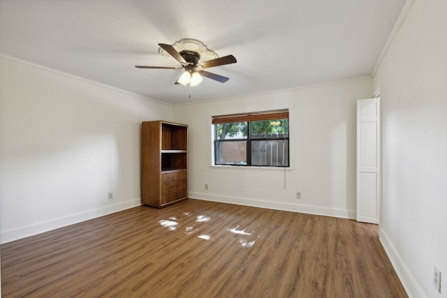 spare room featuring ceiling fan, dark hardwood / wood-style floors, and crown molding