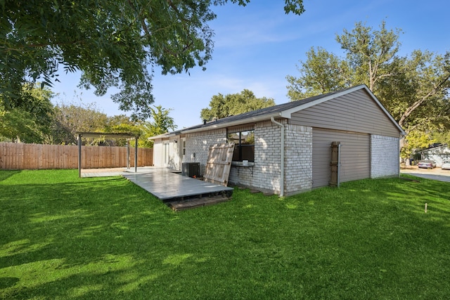 garage with a yard and central AC unit