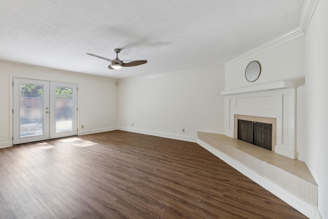 unfurnished living room featuring a fireplace, wood-type flooring, crown molding, ceiling fan, and french doors