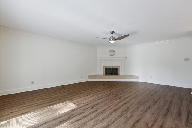 unfurnished living room with a tiled fireplace, ceiling fan, hardwood / wood-style flooring, and crown molding