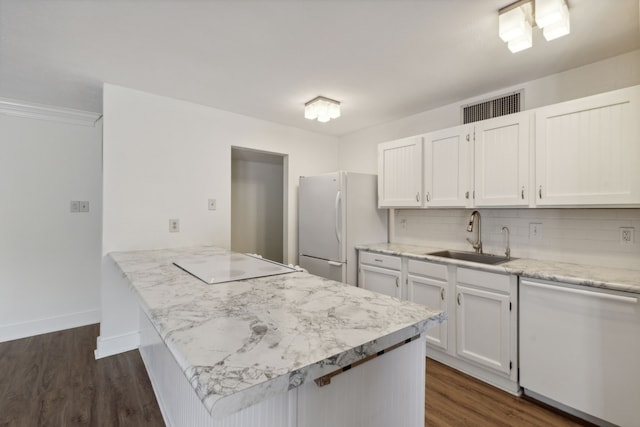 kitchen featuring dark wood-type flooring, tasteful backsplash, sink, white cabinetry, and white appliances