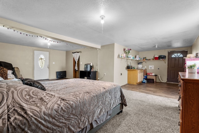 bedroom featuring a textured ceiling, multiple windows, and hardwood / wood-style flooring