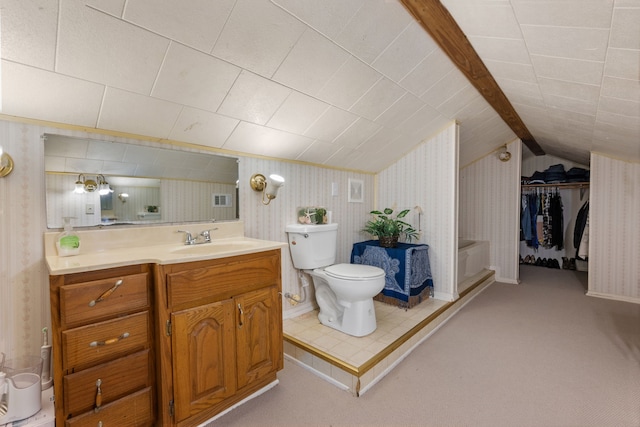 bathroom featuring toilet, vanity, and vaulted ceiling