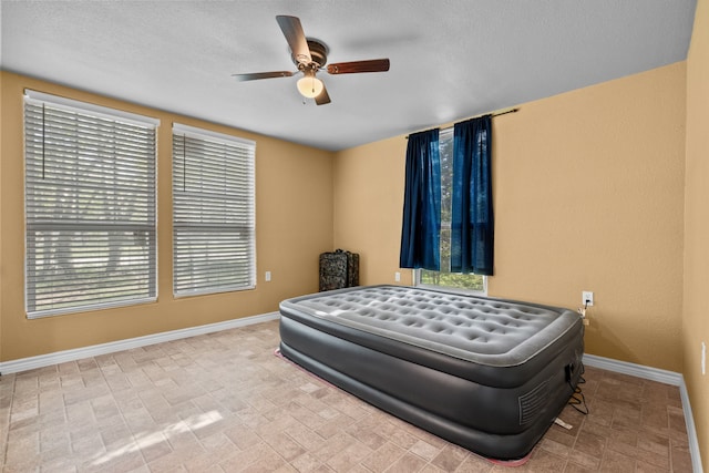 bedroom featuring a textured ceiling and ceiling fan