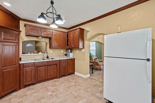 kitchen with sink, crown molding, decorative light fixtures, and white appliances