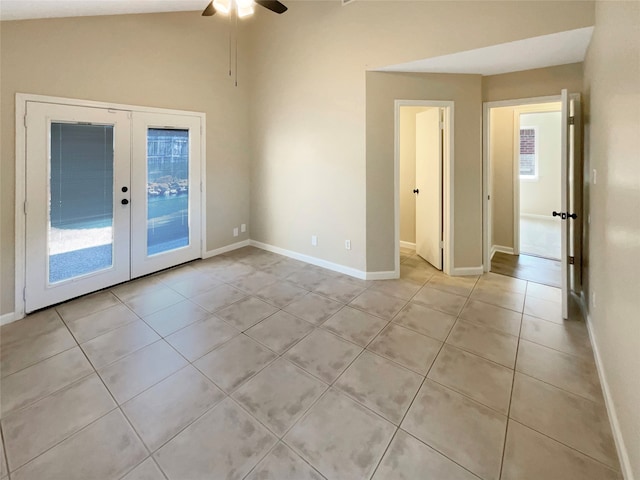 spare room featuring french doors, lofted ceiling, light tile patterned floors, and ceiling fan