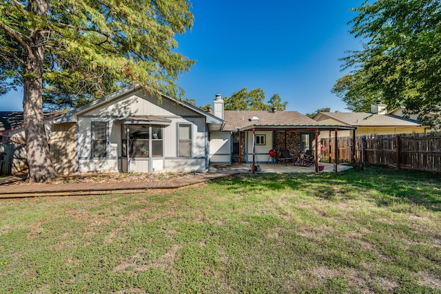 rear view of house with a patio and a yard