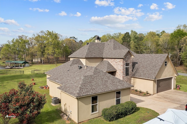 view of front of house featuring cooling unit, a garage, and a front yard