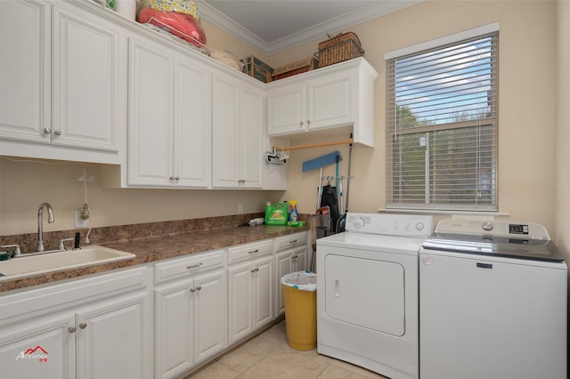 laundry room featuring light tile patterned flooring, independent washer and dryer, crown molding, cabinets, and sink